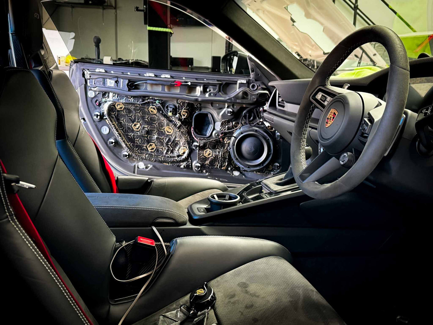 Soundproofing applied to Porsche GT3 door panel with technician working