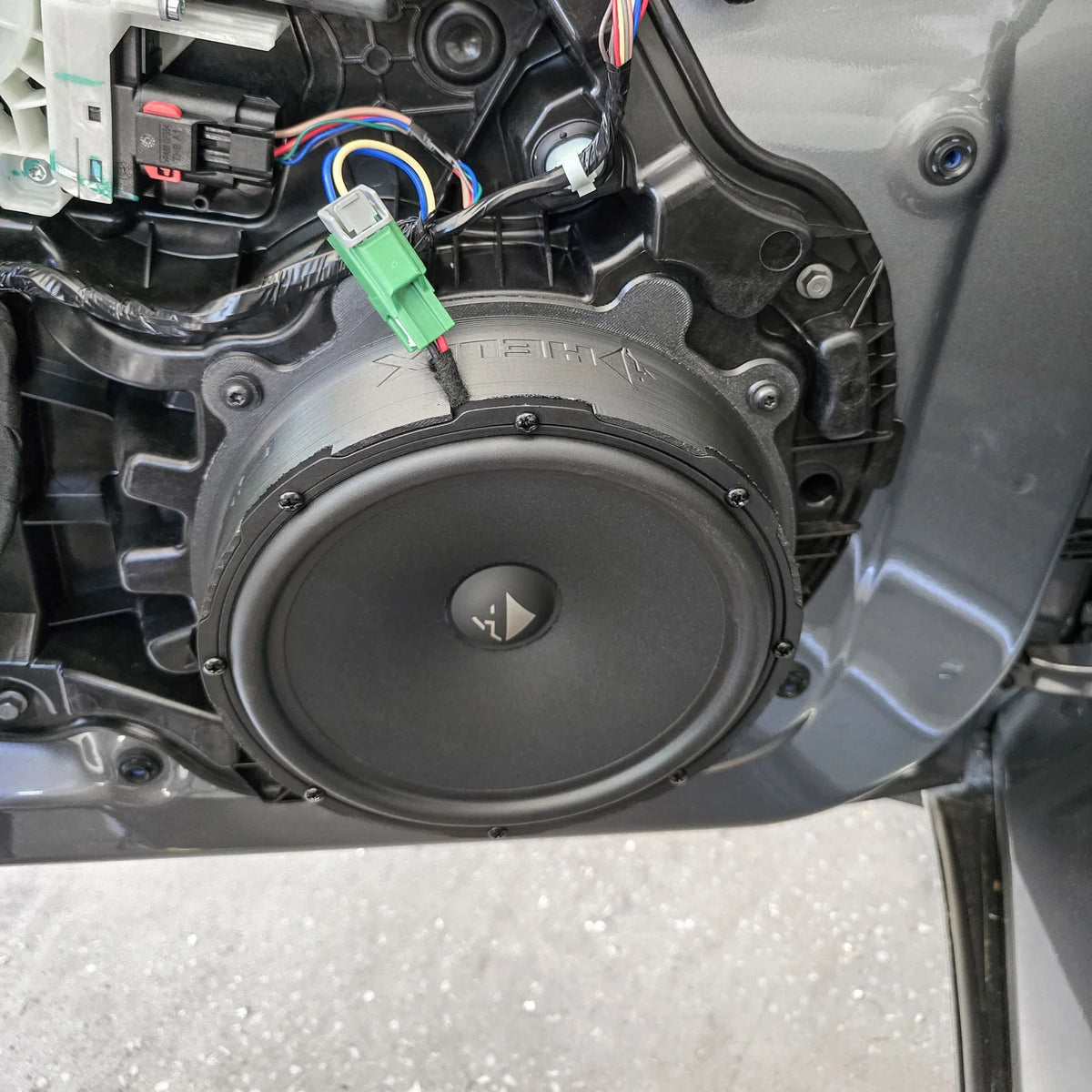 HELIX Ci3 front door woofer fitted with a FlexMount adapter in the Tesla Model Y front speaker upgrade